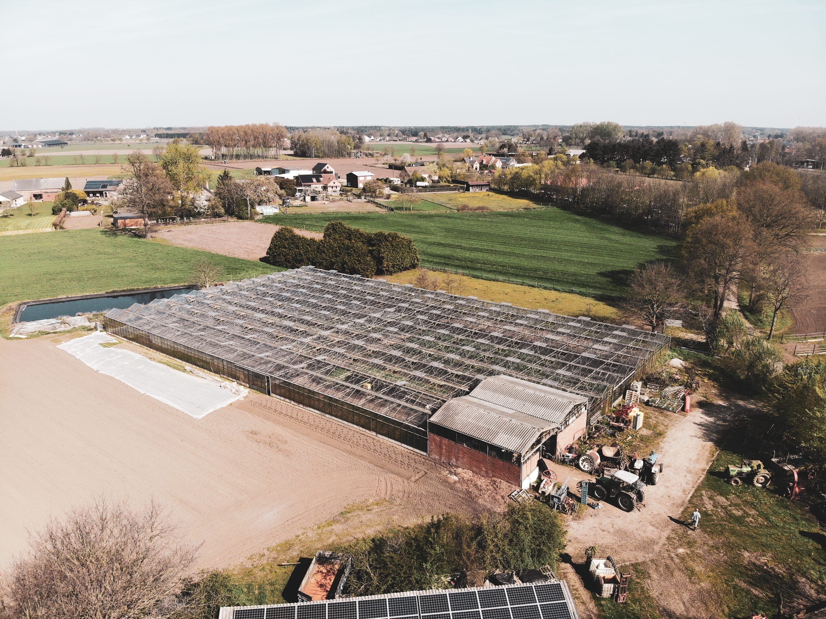 Luchtfoto van de biologische serres en velden van Biohoeve in het voorjaar